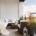 Elegant decorated balcony with rattan outdoor furniture, bright pillows and plants