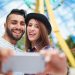 Happy couple making selfie in amusement park