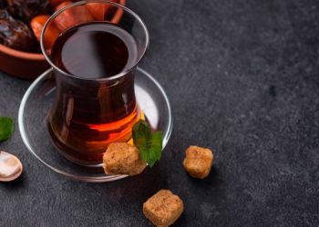 Turkish tea in traditional glass with dried fruits