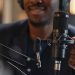 Close up shot of professional condenser microphone and African American male hand setting it up during live podcast in studio