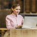 A warehouse worker controlling shipment on laptop.