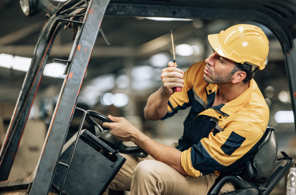 Pracownik firmy relokacyjnej podnosi za pomocą suwnicy część wyposażenia zakładu